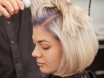 Hairdresser styling young woman hair in beauty salon Hairdresser styling young woman hair in beauty salon